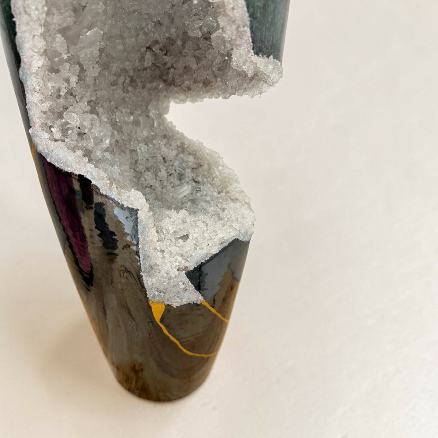 Close-up of a purple ceramic vase with white crystalline mineral growth on its surface.